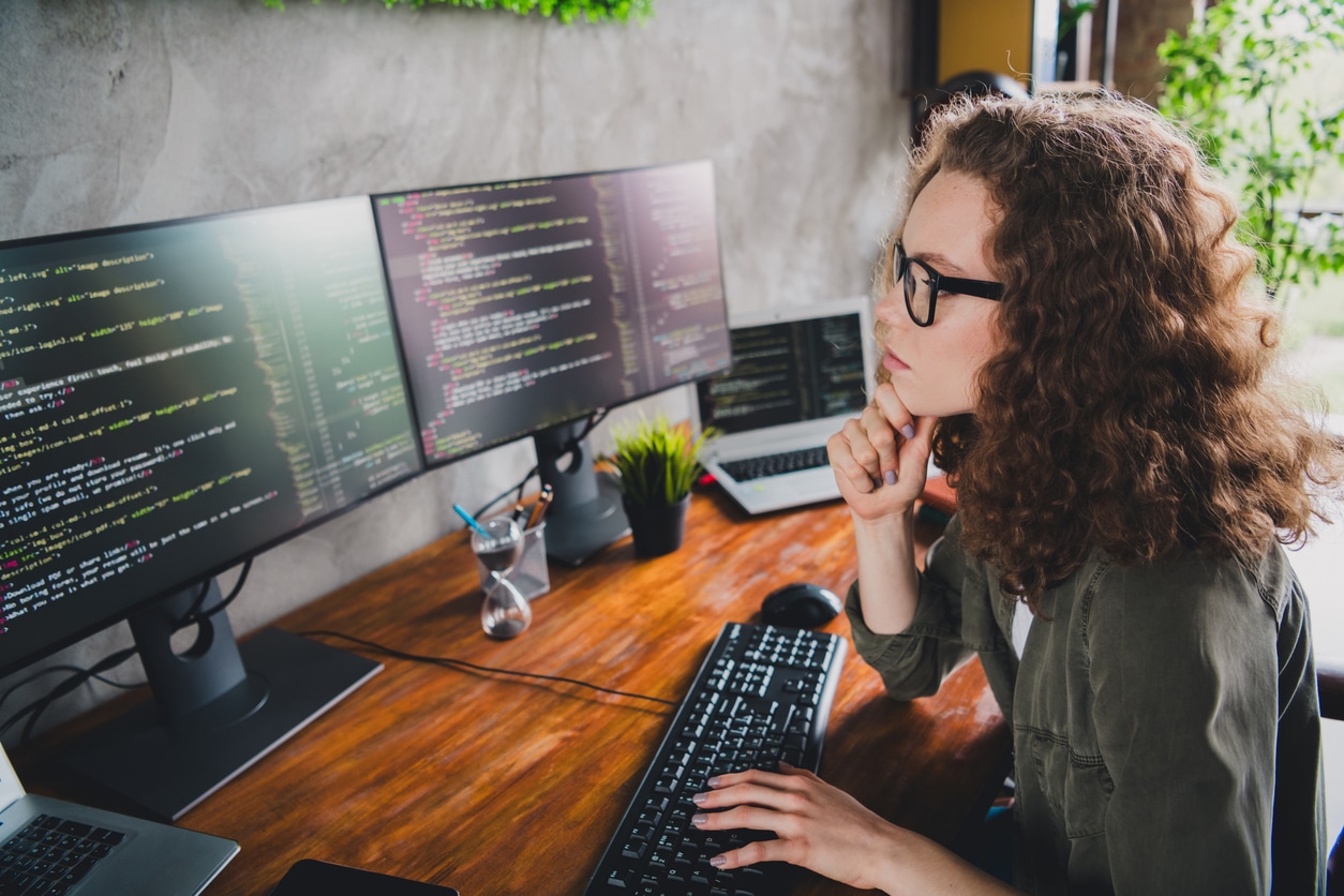 Photo of successful woman coder hacker web creator sitting armchair comfortable workspace workstation indoors.